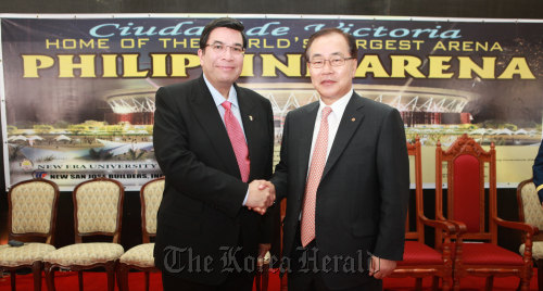 Hanwha E&C vice chairman Kim Hyun-chung (right) and chief of Iglesia Ni Cristo Eduardo Manalo shake hands after the groundbreaking ceremony near Manila on Wednesday.  Hanwha E&C