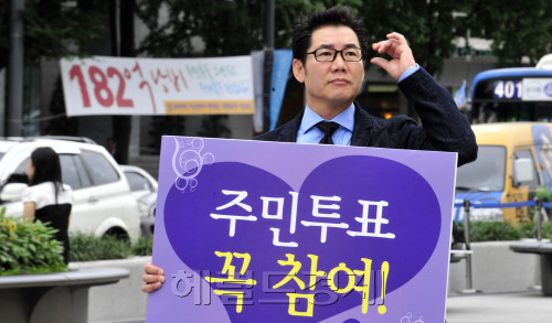 19일 오전 서울 광화문 네거리에서 탤런트 박상원이 무상급식 주민투표 참여 1인 피켓 홍보를 하고 있다. 뒤로 투표 반대 현수막이 걸려 있다.<br />김명섭 기자 msiron@\r\n19일 오전 서울 광화문 네거리에서 탤런트 박상원이 무상급식 주민투표 참여 1인 피켓 홍보를 하고 있다. 뒤로 투표 반대 현수막이 걸려 있다.\n김명섭 기자 msiron@