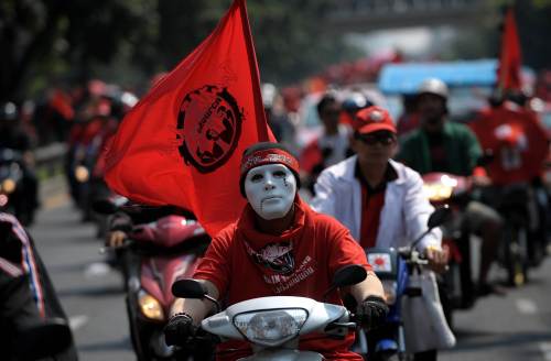 <YONHAP PHOTO-0947> TO GO WITH Lifestyle-Thailand-society-politics,FEATURE by Amelie Bottollier-Depois (FILES) This file photo taken on February 13, 2011 shows a Thai anti-government 'Red Shirts' protester wearing a mask as he rides his motorcycle following a rally outside the criminal court to demand the release of their nine detained leaders in Bangkok. They zip through the traffic-choked streets of Bangkok, but the capital's motorcycle taxis are more than just a means of transportation -- they are also a potent political force. AFP PHOTO / FILES / Christophe ARCHAMBAULT /2011-08-16 12:35:15/ <저작권자 ⓒ 1980-2011 ㈜연합뉴스. 무단 전재 재배포 금지.>\r\nA Thai anti-government “Red Shirts” protester wearing a mask as he rides his motorcycle following a rally outside the criminal court to demand the release of their nine detained leaders in Bangkok on Feb. 13.     AFP-Yonhap News