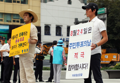 <YONHAP PHOTO-0912> 주민투표, 팽팽한 신경전 (서울=연합뉴스) 신준희 기자 = 무상급식 주민투표를 이틀 앞둔 22일 오후 서울 광화문광장에 엇갈린 입장을 가진 시민 두 명이 함께 1인 피켓 캠페인을 벌이고 있다. 2011.8.22 hama@yna.co.kr/2011-08-22 13:38:22/ <저작권자 ⓒ 1980-2011 ㈜연합뉴스. 무단 전재 재배포 금지.>\r\nWith just two days left to the referendum on free school lunches, two citizens hold pickets ― one (left) calling for a boycott of the vote and the other urging residents to cast ballots, at Gwanghwamun Square in downtown Seoul on Monday. Yonhap News