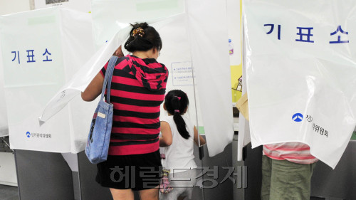 서울시 무상급식 주민투표가 시작된 24일 오전 서울 노원구 월계2동 월계초교에 마련되 투표소에서 한 아이가 엄마의 투표를 보고 있다.<br />김명섭 기자 msiron@\r\n서울시 무상급식 주민투표가 시작된 24일 오전 서울 노원구 월계2동 월계초교에 마련되 투표소에서 한 아이가 엄마의 투표를 보고 있다.\n김명섭 기자 msiron@