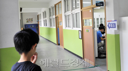 서울시 무상급식 주민투표가 시작된 24일 오전 서울 노원구 월계2동 월계초교에 마련되 투표소에서 한 아이가 투표소를 보고 있다.<br />김명섭 기자 msiron@\r\n서울시 무상급식 주민투표가 시작된 24일 오전 서울 노원구 월계2동 월계초교에 마련되 투표소에서 한 아이가 투표소를 보고 있다.\n김명섭 기자 msiron@