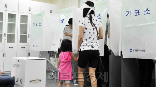서울시 무상급식 주민투표가 시작된 24일 오전 서울 노원구 월계2동 월계초교에 마련되 투표소에서 한 아이가 엄마아 기표소를 들어가고 있다.<br />김명섭 기자 msiron@\r\n서울시 무상급식 주민투표가 시작된 24일 오전 서울 노원구 월계2동 월계초교에 마련되 투표소에서 한 아이가 엄마아 기표소를 들어가고 있다.\n김명섭 기자 msiron@