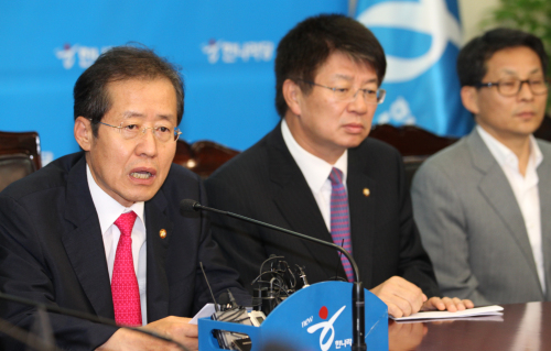 Hong Joon-pyo (left), chairman of the ruling Grand National Party, holds a press conference at the party’s  headquarters in Seoul on Wednesday, after the referendum was declared invalid due to low voter turnout. (Yonhap News)