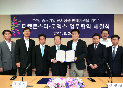 전시산업의 선두 주자 코엑스와 소셜커머스 대표 기업인 티켓몬스터가 24일 코엑스 컨퍼런스센터에서 전시회에 참가하는 유망 중소기업 대상의 유통 지원을 위한 업무협약을 체결했다. 관계자들이 참석한 가운데 홍성원(가운데 왼쪽) 코엑스 사장과 신현성 티켓몬스터 대표가 협약서를 들어보이고 있다.