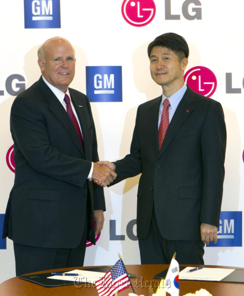 LG Corp. CEO Cho Juno (right) poses with GM CEO Dan Akerson after signing a strategic alliance to jointly develop high-performance electric cars in Detroit on Thursday.     Yonhap News