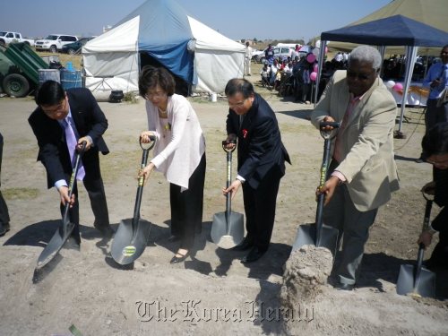 POSCO Africa unit chief Park Joong-seok (far left), Korean Ambassador to Zimbabwe Ryu Kwang-Sok (third from left), Zimbabwe’s Local Government Minister Ignatious Morgan Chombo (far right) and other officials break ground for the steelmaker’s children’s development center in the African country on Friday.   POSCO