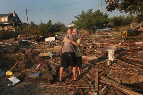 <YONHAP PHOTO-0956> NAGS HEAD, NC - AUGUST 28: Billy Stinson (R) is comforted by his friend David Alan Harvey as he looks over the remains of his cottage August 28, 2011 in Nags Head, North Carolina. The cottage, built in 1903 and destroyed yesterday by Hurricane Irene, was one of the first vacation cottages built on Albemarle Sound in Nags Head. Stinson has owned the home, which is listed in the National Register of Historic Places, since 1963. Scott Olson/Getty Images/AFP== FOR NEWSPAPERS, INTERNET, TELCOS & TELEVISION USE ONLY == /2011-08-29 10:47:21/ <저작권자 ⓒ 1980-2011 ㈜연합뉴스. 무단 전재 재배포 금지.>\r\nA man is comforted by his friend as he stands on what is left of his cottage in North Carolina on Sunday. AFP-Yonhap News