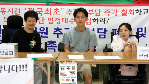 Solidarity Against Disability Discrimination member Jeong Eun-joo (right) campaigns with other activists at City Hall Subway Station, Seoul, Wednesday.   Kirsty Taylor