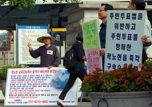 <YONHAP PHOTO-1066> 교육감에 대한 상반된 입장 (서울=연합뉴스) 곽노현 교육감에 대해 서로 다른 입장을 가진 시민, 단체들이 31일 오전 출근시간 종로구 서울시교육청 앞에서 시위를 벌이고 있다. 곽 교육감은 이날 오전 반나절 휴가를 내고 출근하지 않았다. 2011.8.31 hama@yna.co.kr/2011-08-31 10:27:41/ <저작권자 ⓒ 1980-2011 ㈜연합뉴스. 무단 전재 재배포 금지.>\r\nCitizens hold pickets in front of the Seoul Metropolitan Office of Education on Wednesday, with one demanding the resignation of the education chief and the other vowing support for him.   Yonhap News