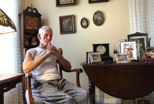 Fred Odena, who is a former engineer and has Alzheimer’s disease, sits next to family pictures in his home near Orlando, Florida.  MCT