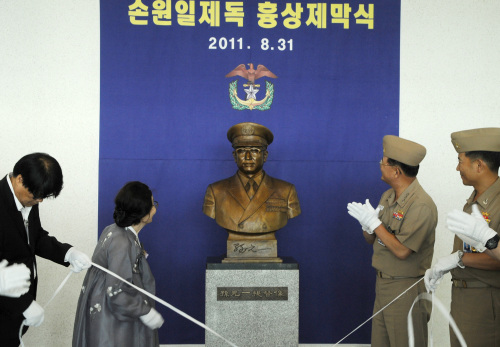 Hong Eun-hye (left), widow of the late admiral Sohn Won-il, and a naval officer unveil his bronze bust at the Naval Academy in Changwon, South Gyeongsang Province, Wednesday. (Yonhap News)