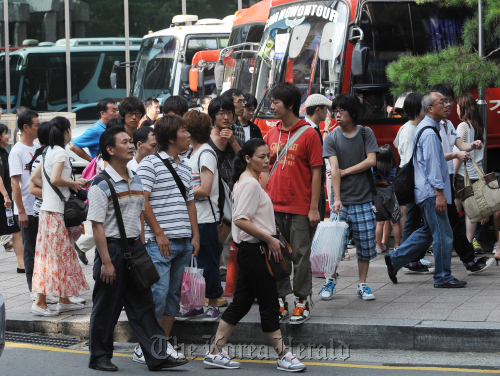 동화면세점 앞 중국관광객<br />이상섭 기자 babtong@heraldm.com 2011.09.01\r\nTourists wait for their tour bus after shopping at Dongwha Duty Free Shop in Gwanghwamun on Thursday.    Lee Sang-sub/The Korea Herald