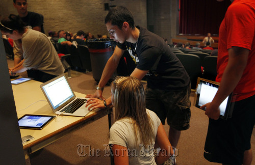 <YONHAP PHOTO-1114> In this Aug. 23, 2011 photo, Eric Calandriello lends tech support to senior Jean Harafin, 17, after she and other students received iPads at Burlington High School in Burlington, Mass. Burlington is giving iPads this year to every one of its 1,000-plus high school students. Some classes will still have textbooks, but the majority of work and lessons will be on the iPads. (AP Photo/Elise Amendola)/2011-09-03 21:21:33/ <저작권자 ⓒ 1980-2011 ㈜연합뉴스. 무단 전재 재배포 금지.>\r\nEric Calandriello lends tech support to senior Jean Harafin, after she and other students received iPads at Burlington High School in Burlington, Massachusetts.  AP-Yonhap News