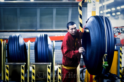 A factory worker produces tires at the Pirelli & C SpA tire factory in Jining, Shandong Province, China.  Bloomberg