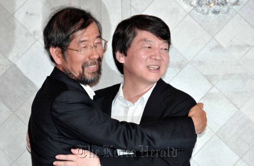 Prof. Ahn Cheol-soo (right) and civic activist Park Won-soon embrace after Ahn’s announcement on Tuesday that he will support Park in next month’s Seoul mayoral by-election.  Chung Hee-cho/The Korea Herald
