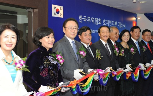 Korea International Trade Association chairman SaKong Il (third from left), Ho Chi Minh City Vice Mayor Nguyen Thi Hong (second from left), Korean ambassador to Vietnam Ha Chan-ho (fifth from left), SeAH Steel Corp. chairman Lee Woon-hyung (eighth from left) and other officials cut the tape at a ceremony to launch KITA’s regional office on Wednesday in the Vietnamese city. KITA