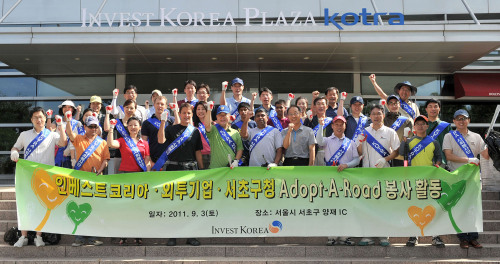 Volunteers stop for a picture during an event to clean the streets of Seoul. (Invest Korea)