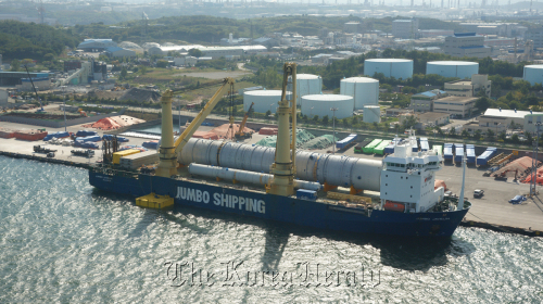 The crude column produced by SK Engineering and Construction Co. sits on board the Dutch ship that will carry it to the United Arab Emirates at an Ulsan port on Wednesday.  SK E&C