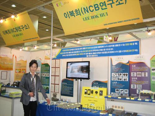 Lee Bok-hui shows off the material she invented out of construction waste. Yonhap News