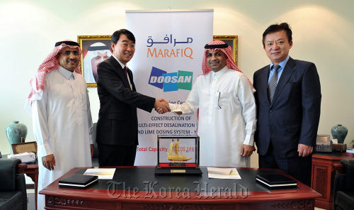 Doosan Heavy Industries & Construction Co.’s water business chief Yoon Seok-won (second from left), Marafiq chief executive Thamer Al-Sharhan (third from left) and other officials pose after they signed a deal on Tuesday in Jubail to construct a desalination plant in Saudi Arabia.    Doosan Heavy