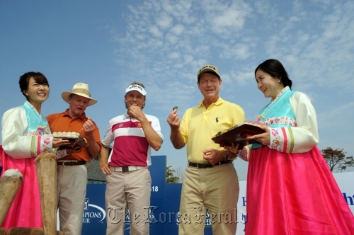 World golf hall of famer Tom Kite (second from left), Bernhard Langer (center) and eight-time major champion Tom Watson (second from right) try songpyeon at the Jack Nicklaus Golf Club in Incheon on Tuesday.  Songdo IBD Championship