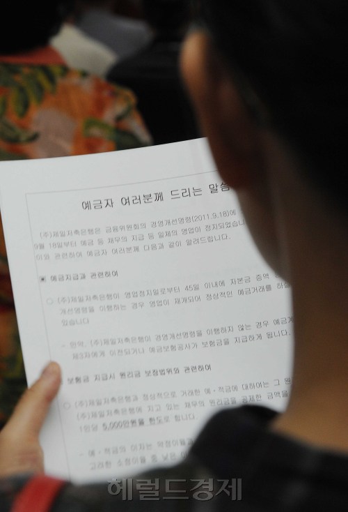 어제 금융당국이 부실저축은행 7곳에 대한 추가 영업정지 조치를 취한 가운데 19일 오전 서울 송파구 가락동 제일저축은행 본사에서 한 예금자가 서류를 읽고 있다.<br />이상섭 기자. babtong@heraldm.com 2011.09.19\r\n어제 금융당국이 부실저축은행 7곳에 대한 추가 영업정지 조치를 취한 가운데 19일 오전 서울 송파구 가락동 제일저축은행 본사에서 한 예금자가 서류를 읽고 있다.\n이상섭 기자. babtong@heraldm.com 2011.09.19