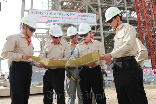 Hanwha E&C employees brief CEO Kim Hyun-chung (second from right) about the progress on the works on the power plant being built in Saudi Arabia’s Yanbu industrial complex.         Hanwha E&C