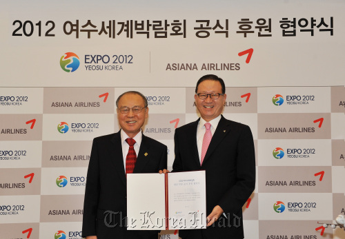 Asiana Airlines CEO Yoon Young-doo (right) and Organizing Committee for Expo 2012 Yeosu Korea chairman Kang Dong-suk pose after signing the sponsorship contract in Incheon International Airport on Sunday.  Asiana Airlines