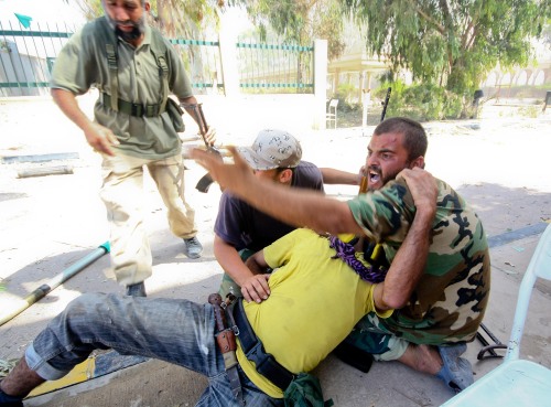 <YONHAP PHOTO-1054> (110924) -- SIRTE, Sept. 24, 2011 (Xinhua) -- A fighter of Libya's ruling National Transitional Council (NTC) screams for help after his comrade was shot by a sniper during heavy battles at the entrance of Al-Etha'a street, about 7 kilometers from the heart of sirte, Libya, Sept. 24, 2011. NTC forces, backed by NATO warplanes, have marched into Sirte, the hometown of former Libyan leader Muammar Gaddafi, after fierce fighting with troops loyal to Gaddafi, Qatar-based al-Jazeera television reported Saturday. (Xinhua/Amru Salahuddien) /2011-09-25 11:17:52/ <저작권자 ⓒ 1980-2011 ㈜연합뉴스. 무단 전재 재배포 금지.>\r\nA Libyan fighter screams for help after his comrade was shot during heavy battles at the entrance of Al-Etha’a street, about 7 kilometers from the heart of Sirte on Saturday. Xinhua-Yonhap News