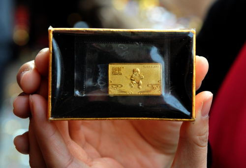This photo shows the first customer to use the country's first gold vending machine displaying her gold bar in the popular Wangfujing Street in Beijing. (AFP-Yonhap News)