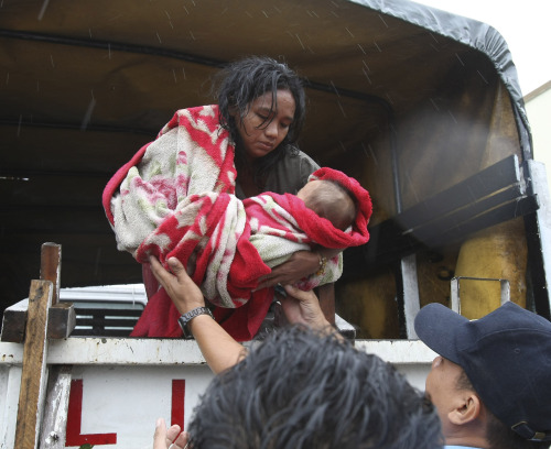 <YONHAP PHOTO-1374> A mother arrives at an evacuation center with her baby after being rescued by police at the height of typhoon Nesat Tuesday Sept. 27, 2011 in Manila, Philippines. Typhoon Nesat, with winds of up to 133 miles (215 kilometers), slammed the northeastern Philippines Tuesday, unleashing floods, cutting power, halting work in the capital and forcing thousands of residents to flee to evacuation centers. (AP Photo/Bullit Marquez)/2011-09-27 14:47:20/ <저작권자 ⓒ 1980-2011 ㈜연합뉴스. 무단 전재 재배포 금지.>\r\nA woman arrives at an evacuation center with her baby after being rescued by police on Tuesday in Manila. AP-Yonhap News