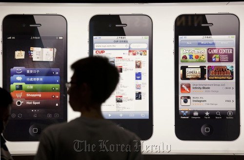 A man lines up near the new Apple Inc. store on the eve of the store’s opening in Hong Kong on Friday.  Bloomberg
