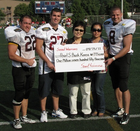 Sharing page picture\r\nFrom left: Ian MacLeod, Lawrence Bowlby, Kyunghee Bae, Lee Hye-Young and Jason Braedon pose as the Warriors hand over a 2 million won check to the Pearl S. Buck Foundation. William du Plessis