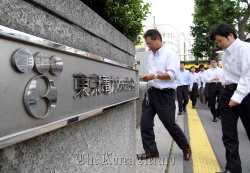 Employees of Tokyo Electric Power Co. enter the company’s headquarters in Tokyo.  Bloomberg
