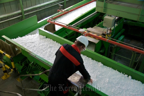 A LANXESS worker checks the rubber crumbs on the assembly line in Port Jerome, France.  LANXESS