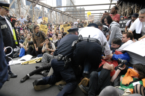 Police make their way a crowd of protesters who were the front line on New York's Brooklyn Bridge when police began making arrests during Saturday's march by Occupy Wall Street. (AP-Yonhap News)