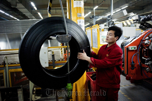 A factory worker produces tires at the Pirelli & C SpA tire factory in Jining, Shandong Province.  Bloomberg