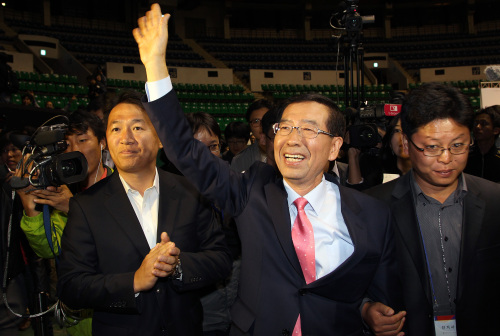 <YONHAP PHOTO-1422> 범야권 단일후보 박원순 인사 (서울=연합뉴스) 전수영 기자 = 서울시장 야권 단일후보 선출 국민참여경선에서 민주당 박영선 후보를 누르고 단일후보가 된 시민사회 박원순 후보가 3일 오후 서울 장충체육관에서 지지자들을 향해 손을 들어 인사하고 있다. 2011.10.3 swimer@yna.co.kr/2011-10-03 20:38:23/ <저작권자 ⓒ 1980-2011 ㈜연합뉴스. 무단 전재 재배포 금지.>\r\nPark Won-soon waves at a gymnasium in Seoul on Monday after winning the vote by party members and citizens to decide the unified liberal candidate.  Yonhap News