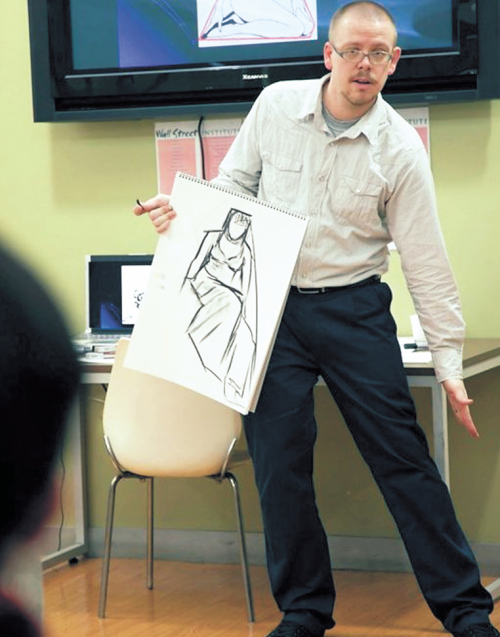 Mike Stewart holds up a sketch during one of his art classes at his\r\nexisting Seoul studio. (Jankura Artspace)
