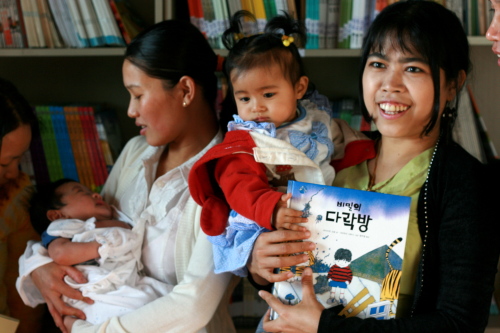 Jumma mothers hold their children at the new Jum library in Yangchon, Gyeonggi Province.    Kirsty Taylor