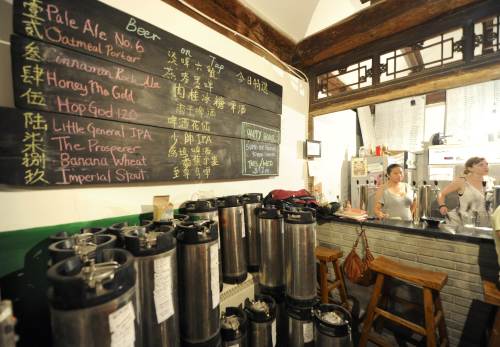 <YONHAP PHOTO-1515> TO GO WITH AFP STORY Lifestyle-China-beer,FEATURE by Allison Jackson The photo taken on July 23, 2011 shows a bartenders (R) working at the Great Leap bar in Beijing. In a pokey room in a backstreet of Beijing, self-taught brewer Carl Setzer uses spicy Sichuan peppercorns, Oolong tea leaves and cinnamon to invent beer flavours suited to Chinese taste-buds. AFP PHOTO / LIU JIN /2011-10-05 13:03:21/ <저작권자 ⓒ 1980-2011 ㈜연합뉴스. 무단 전재 재배포 금지.>\r\nBartenders working at the Great Leap bar in Beijing.      AFP-Yonhap News