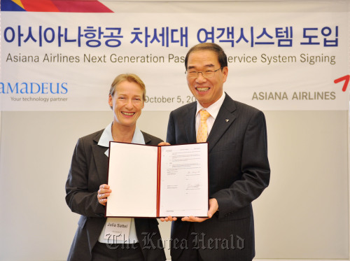 Chief of Asiana Airlines’s passenger business unit Ryu Kwang-hee (right) and Amadeus vice president Julia Sattel pose at the carrier’s headquarters in Seoul on Wednesday after signing an agreement to jointly develop automated travel management solutions. Asiana Airlines