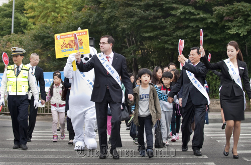 Francois Provost, CEO of Renault Samsung Motors, participates in a campaign for child safety by encouraging drivers to slow down when near school zones at an elementary school in Chang-dong, Seoul on Thursday.  Renault Samsung Motors
