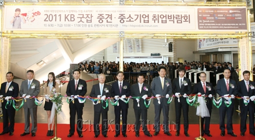 Prime Minister Kim Hwang-sik (sixth from left) poses with KB Financial Group President Lim Young-rok (fourth from left) and KB Kookmin Bank President Min Byong-deok (second from right) during the opening ceremony for a job fair hosted by the group at the Songdo Convensia in Incheon on Thursday.  KB Financial Group