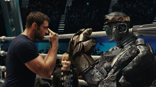 Charlie Kenton (Hugh Jackman, left) gives instructions to Atom while his son, Max (Dakota Goyo) looks on in DreamWorks Pictures’ action drama “Real Steel.” (Melissa Moseley/Courtesy DreamWorks Pictures/MCT)