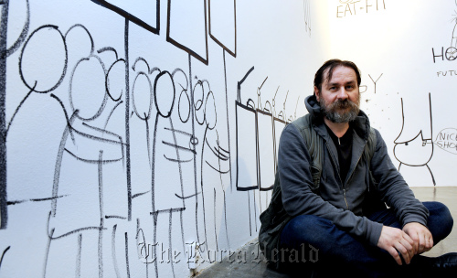 아티스트 댄 퍼찹스키 토탈미술관 인터뷰. 박현구 기자phko@heraldm.com 2011.09.29\r\nDan Perjovschi sits in front of a wall filled with his drawings at Total Museum in Pyeongchang-dong, central Seoul.  Park Hyun-koo/The Korea Herald