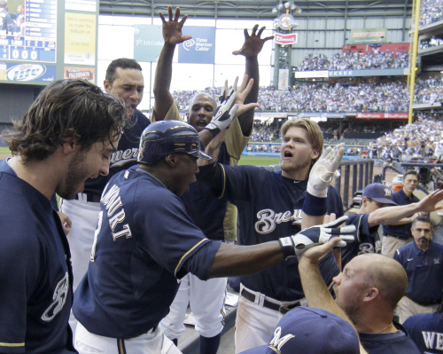 <YONHAP PHOTO-0718> Milwaukee Brewers' Yuniesky Betancourt is congratulated in the dugout after hitting a two-run home run during the fifth inning of Game 1 of baseball's National League championship series against the St. Louis Cardinals Sunday, Oct. 9, 2011, in Milwaukee. (AP Photo/David J. Phillip)/2011-10-10 07:21:53/ <저작권자 ⓒ 1980-2011 ㈜연합뉴스. 무단 전재 재배포 금지.>\r\nMilwaukee Brewers shortstop Yuniesky Betancourt (center) is congratulated after hitting a two-run home run in the fifth inning.  AP-Yonhap News