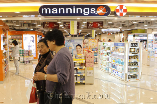 People walk past a Mannings store in Hong Kong.  Bloomberg