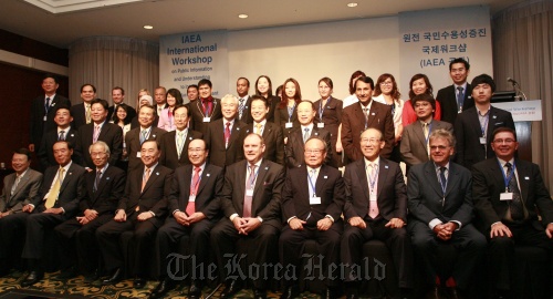 Participants of the workshop on public information on introducing new nuclear power plants including Korea Nuclear Energy Promotion Agency chairman Rhee Jae-hwan (fifth from left, front row) and International Atomic Energy Agency deputy director general Alexander Bychkov (sixth from left, front row) pose at the Lotte Hotel World in southeastern Seoul on Monday.         KNEPA